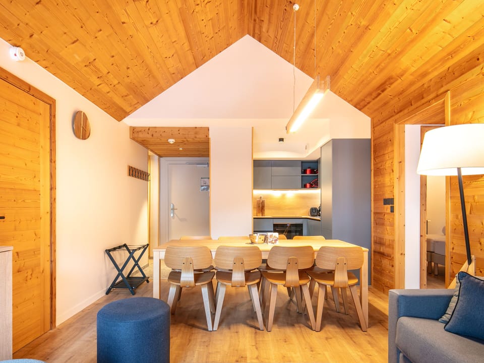 Gather around the modern dining table, where wood accents create a cozy, inviting atmosphere.