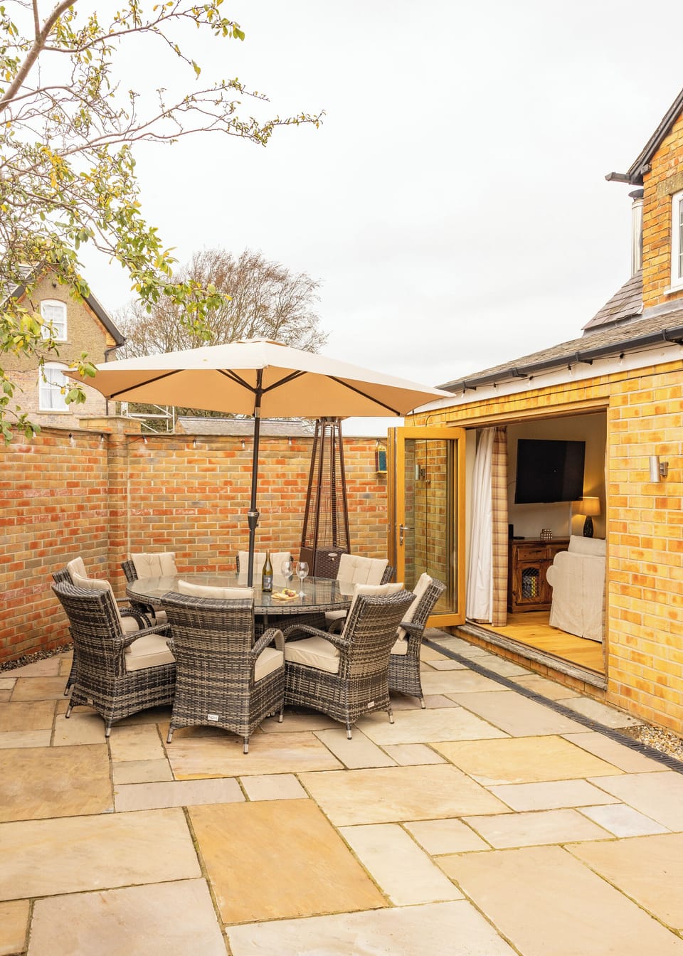 A charming patio retreat featuring comfortable seating and a heater — ideal for unwinding or sharing stories with loved ones.