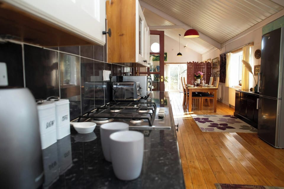 Kitchen counter with mug and toaster beside gas hob, looking towards dining table
