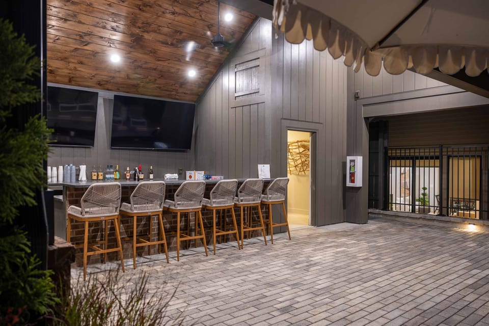 Pool pavilion includes dining area, mini fridge, outdoor furniture, and sun loungers
