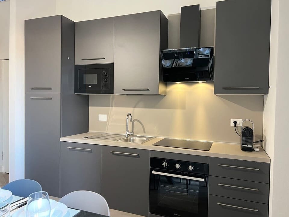 Vista cucina completa con forno, forno microonde, piano induzione, frigorifero, freezer e tutti gli altri accessori.