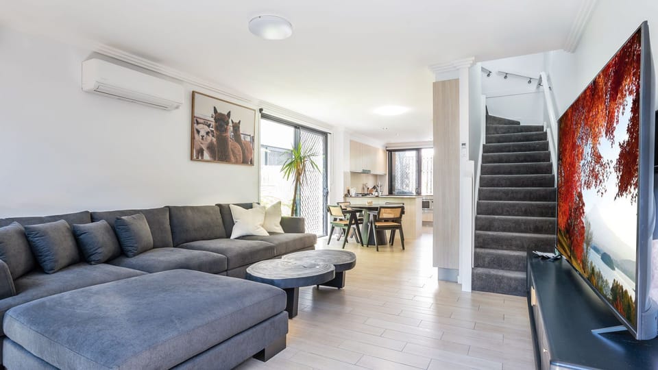 Open-plan living and dining area with large sectional sofa.