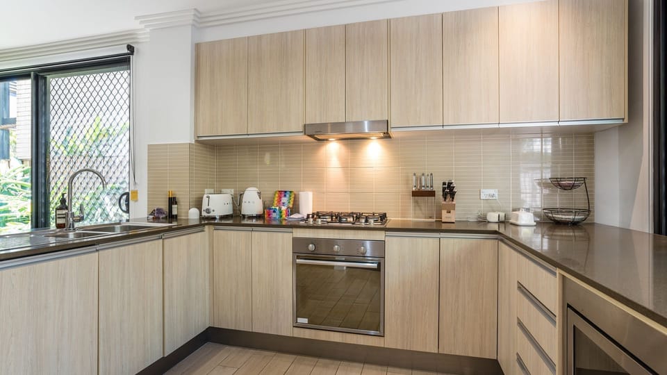 Full kitchen with gas cooktop, oven, and modern cabinetry.