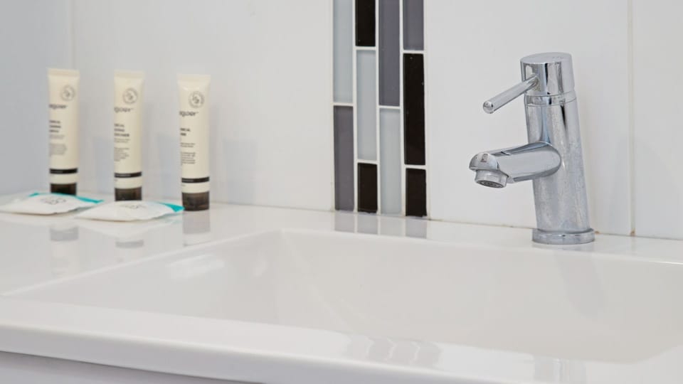 Modern vanity area with essential toiletries provided.