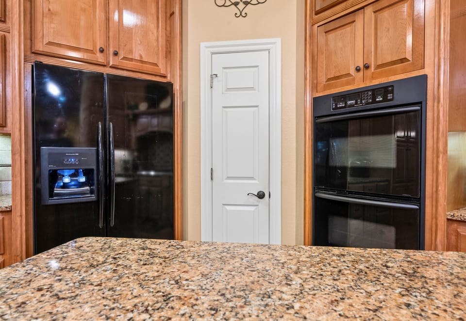 Granite island with plenty of prep space and pantry access.
