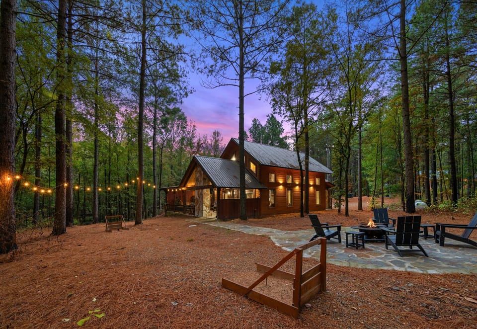Charming exterior view of Wolf Creek glowing in the forest at dusk.