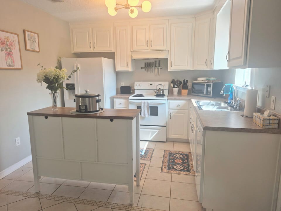 frig freezer stove with oven double sinks lots of cabinets island with storage including cookware dishes silverware bowls and all utensils needed. 