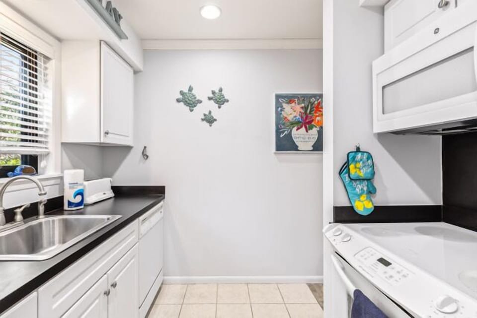 Stainless steel appliances including a dishwasher and glass-top stove.