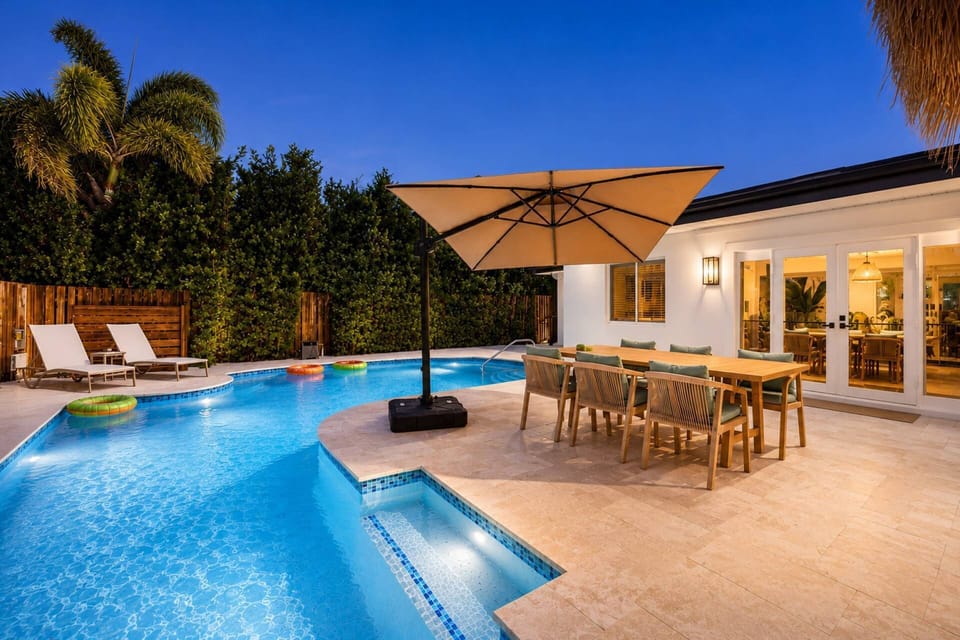 The backyard transforms into a relaxing evening retreat with ambient lighting and resort-inspired outdoor living spaces.