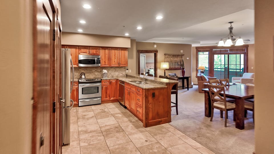 Spacious kitchen with island, granite counters, and wood cabinets.