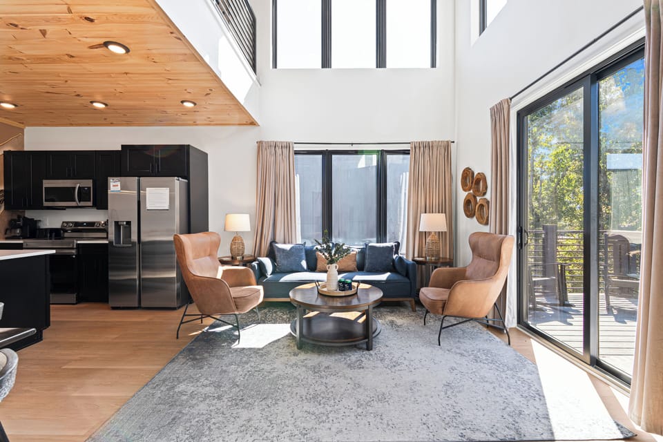 Bright and airy living room with comfortable seating, fireplace and easy access to the deck.