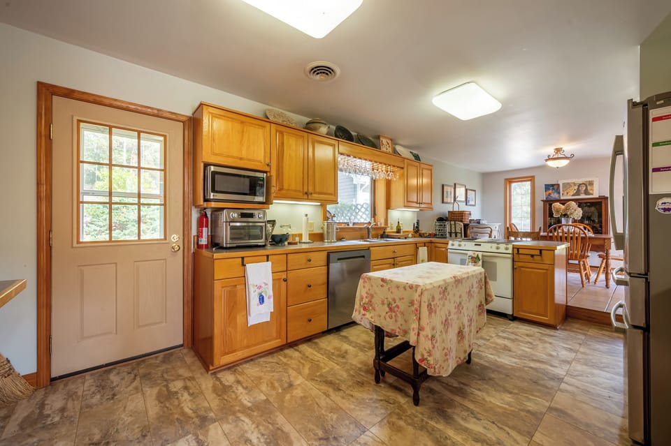 Full kitchen with wood cabinetry and prep table