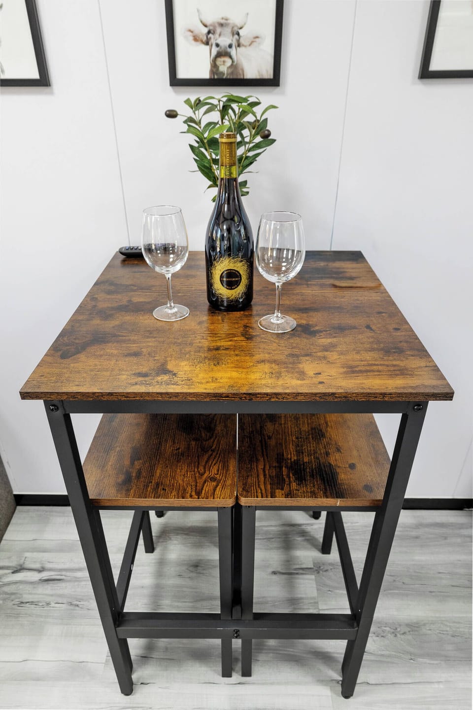 Share a cozy farm-style meal or a glass of wine at this charming wood-and-iron table made for two.