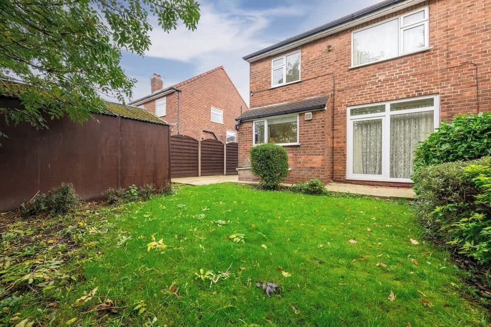 Step out into a generous rear garden with mature hedges and lawn, perfect for morning coffee or letting the kids play