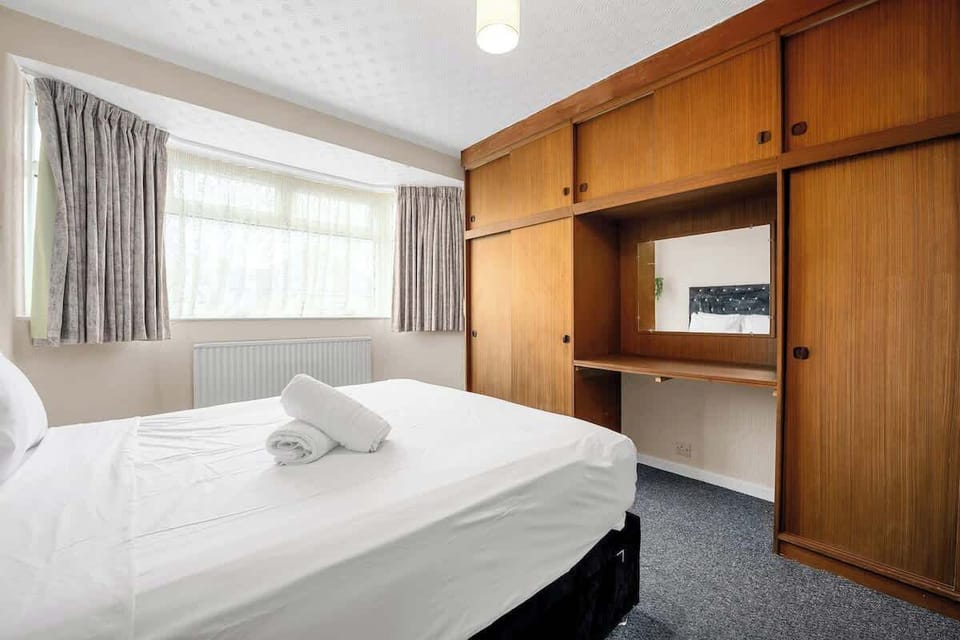 Wake up to natural light in this inviting queen bedroom, complete with fresh linens and soft pillows for every guest