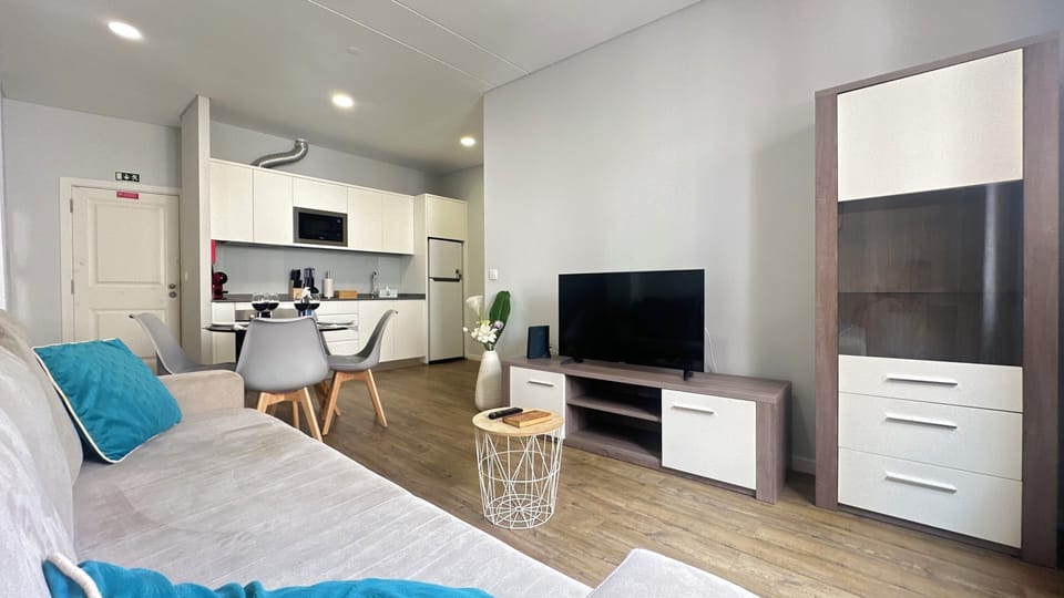 Sofá-cama espaçoso e confortável, e televisão de ecrã plano.