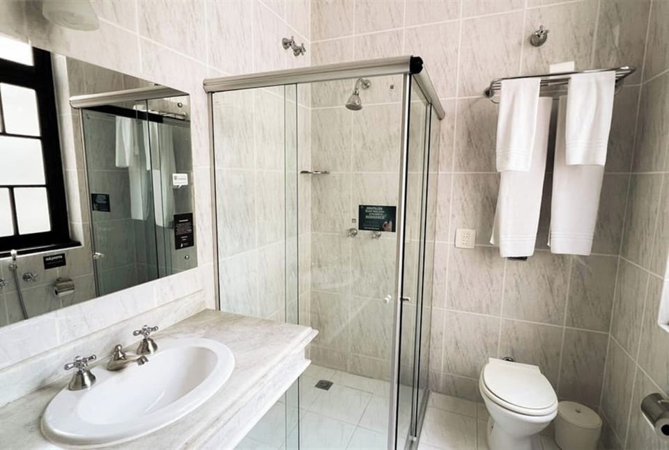 Refresh in a bright marble bath with glass walk-in shower.