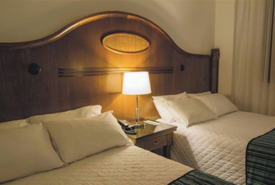 Step into a roomy twin bedroom with natural daylight.