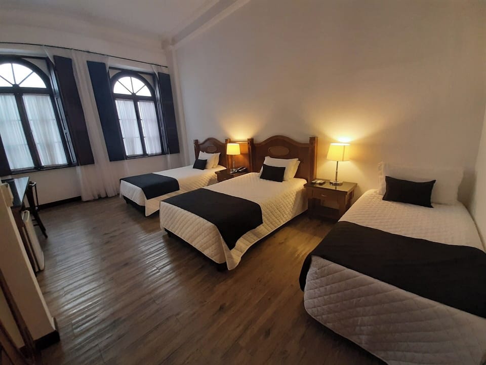 Unwind in a spacious triple room with warm bedside glow.