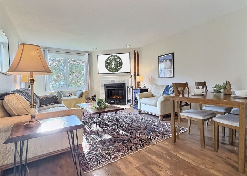Relax in our warm and inviting living room, featuring a crackling fireplace, plush seating, and vintage ski decor.