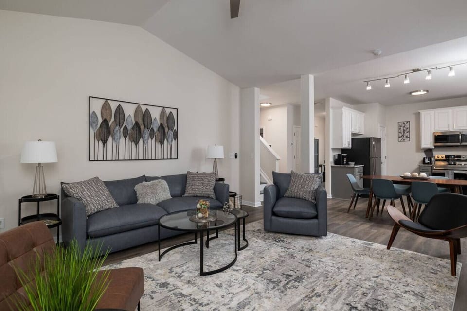Large living room with multiple seating areas and a smart TV.
