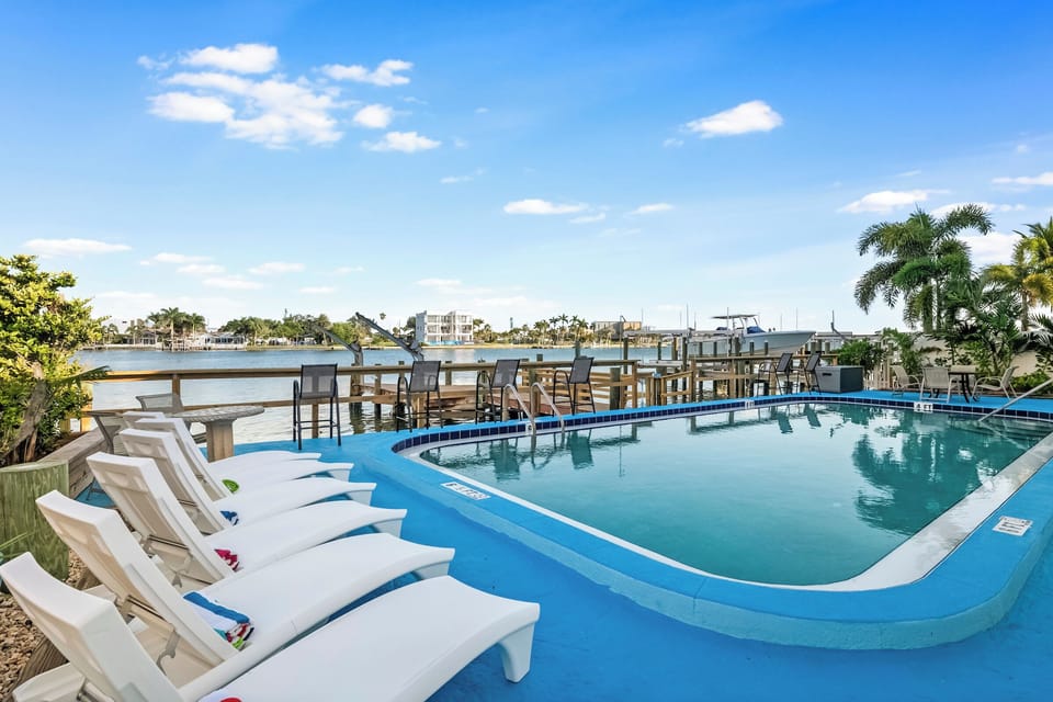 Infinity-style pool with loungers facing the tranquil bay.