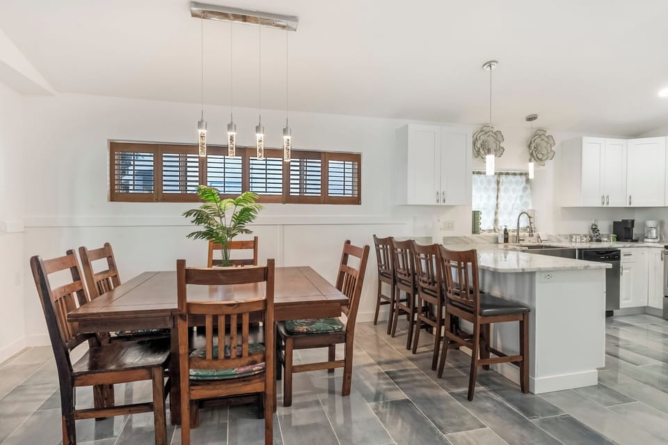 Dining area with wooden table and chandelier lighting.