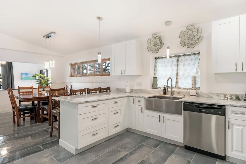 Bright kitchen with white cabinets, island, and bar stools.