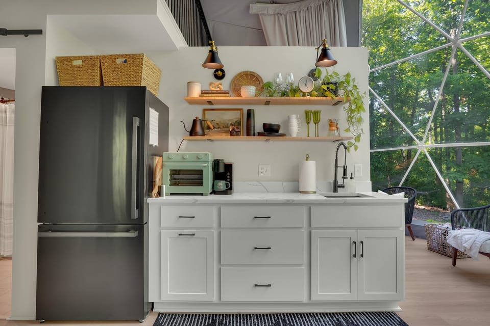 Kitchenette shelves equipped with plates, bowls, glasses, and mugs.