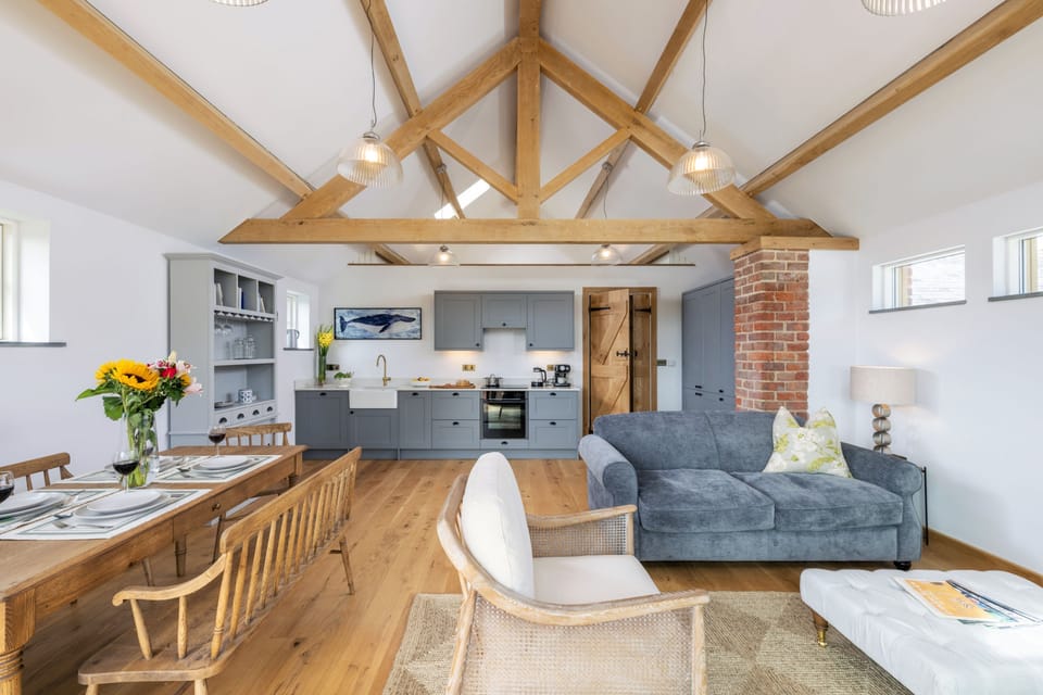 Spacious open-plan living area with vaulted ceiling and exposed beams