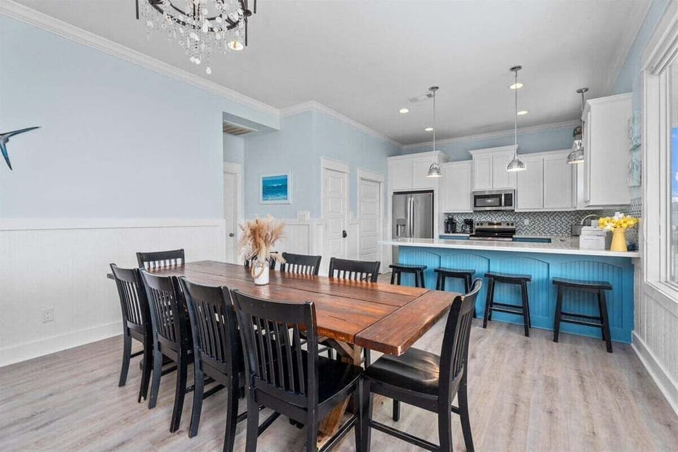 Open dining space with a large table for group meals, connected to a fully equipped kitchen—ideal for family-friendly vacation stays in Crystal Beach TX.
