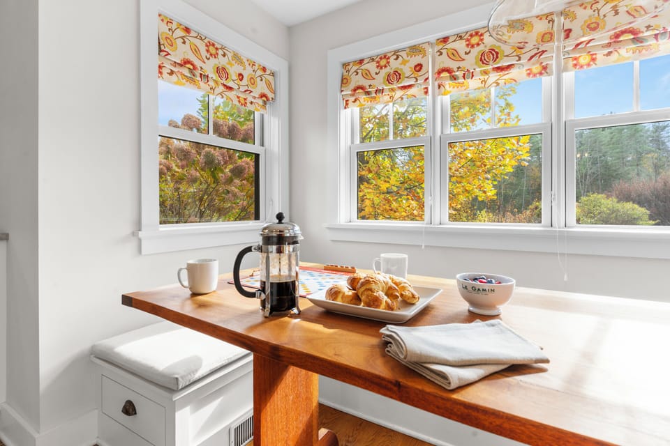 Breakfast nook with windows and a table set for coffee.