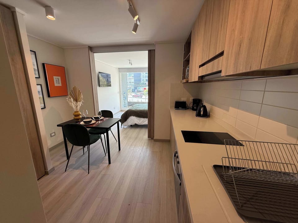 Cozy studio kitchen with modern amenities and a charming dining nook, perfect for intimate meals.