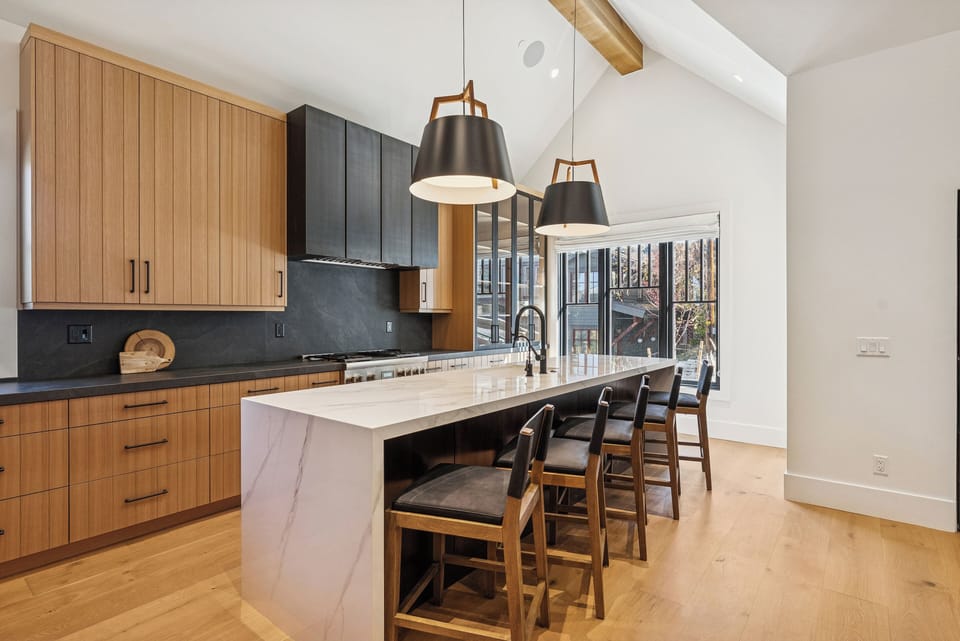 Spacious dining area with wooden table and pendant lighting, seamlessly connected to the kitchen.