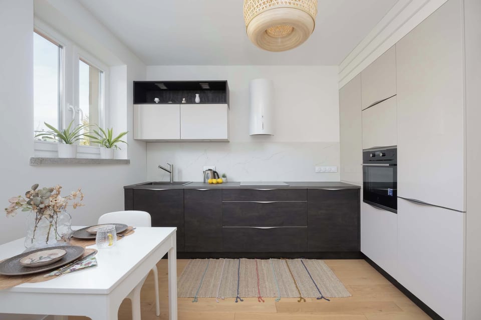 The modern kitchen combined with a dining area offers a comfortable space for shared meals in a bright, sunny interior.