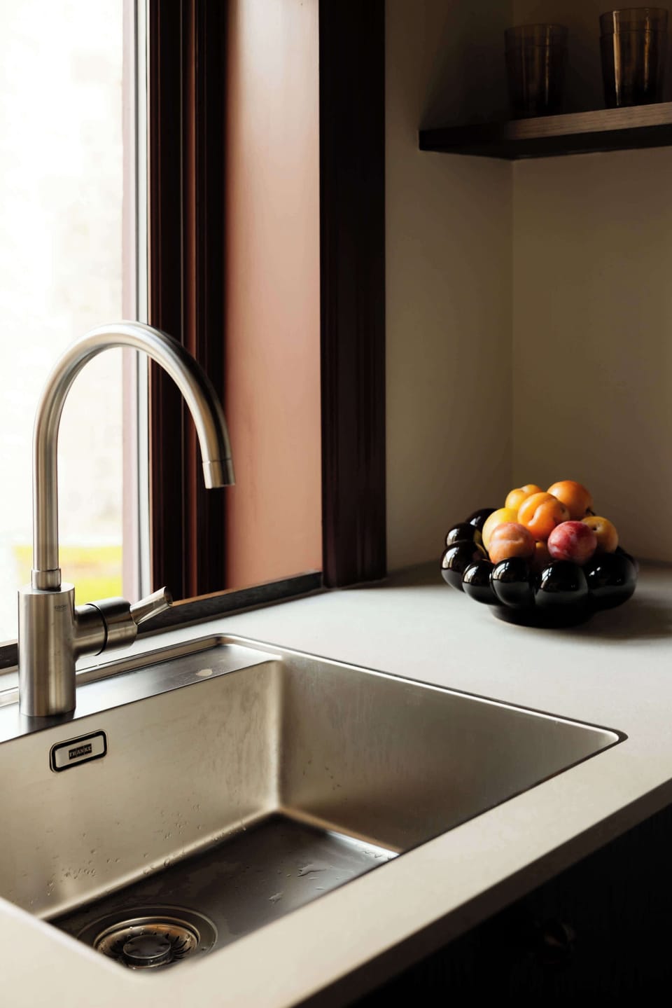 Natural light and modern finishes make everyday moments—like washing fruit or brewing coffee—feel calm and effortless.
