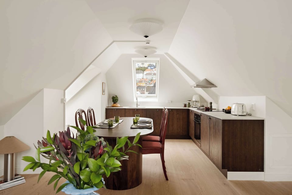 Enjoy open-plan living under charming attic beams—sunlight fills the space, creating a calm and inspiring setting for both work and relaxation