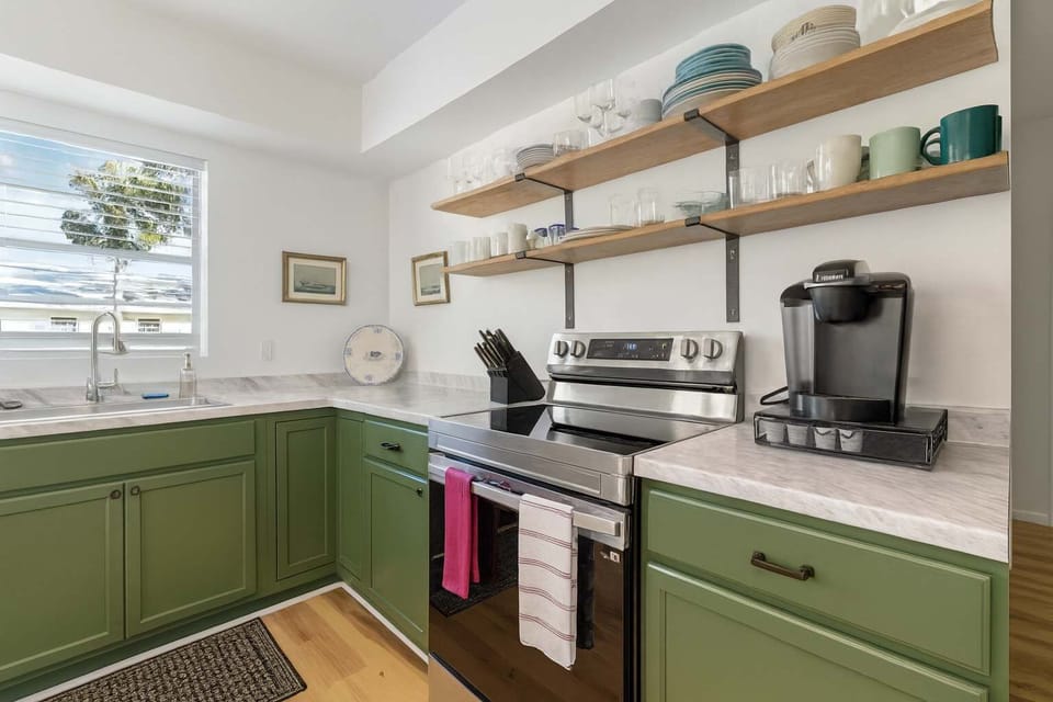 Fully stocked kitchen with Keurig, smart electric stove/oven, GE fridge & dishwasher. Complete cookware, dishes, utensils & prep tools included. Cook vacation meals or prep snacks for your Florida adventures in this stylish sage-green space.