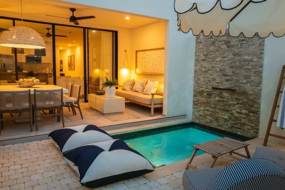 Private plunge pool surrounded by lush greenery and sun loungers.