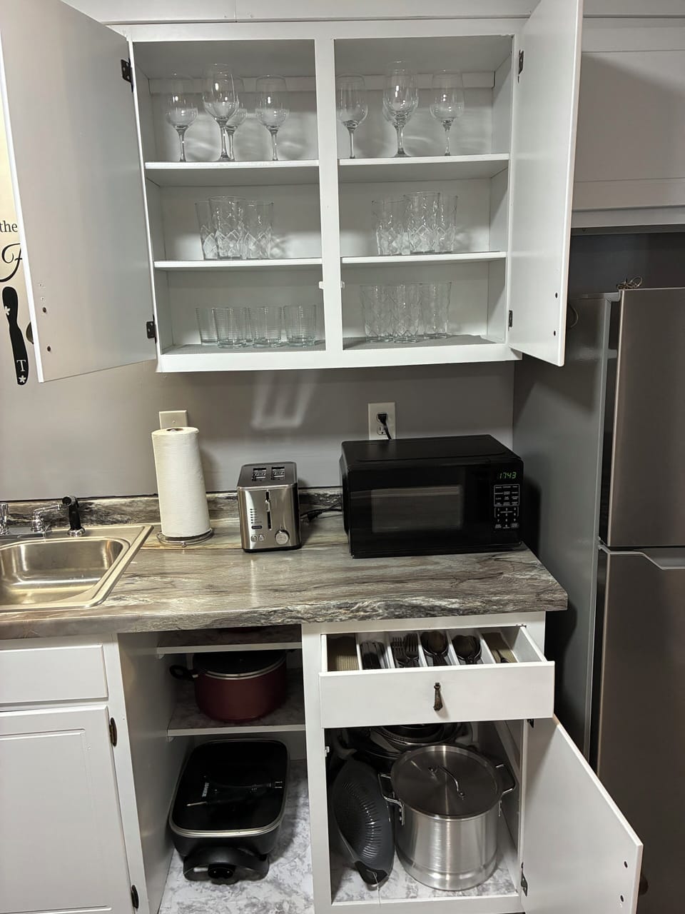 Fully equipped kitchen with pots, utensils, wine glasses, and essentials.