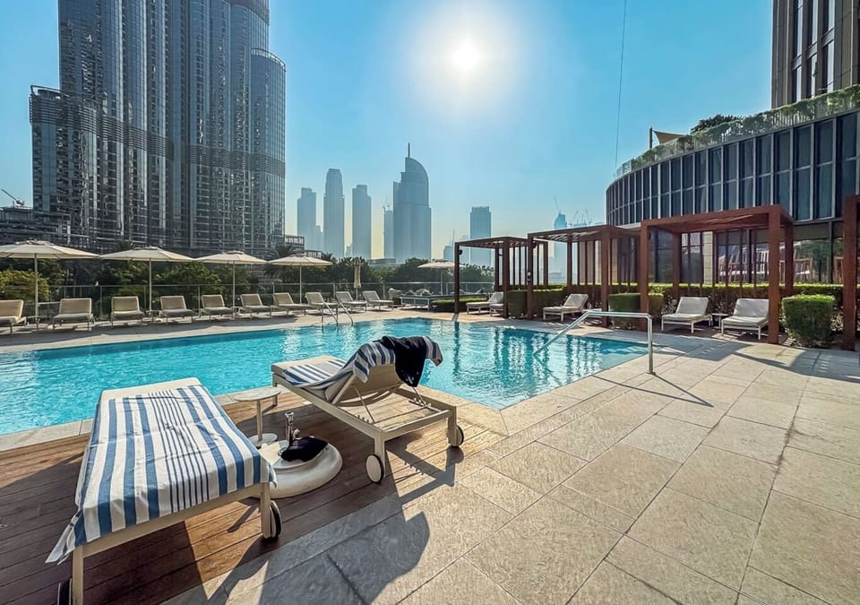 Luxury poolside escape with sunlit loungers and stunning Burj Khalifa views.