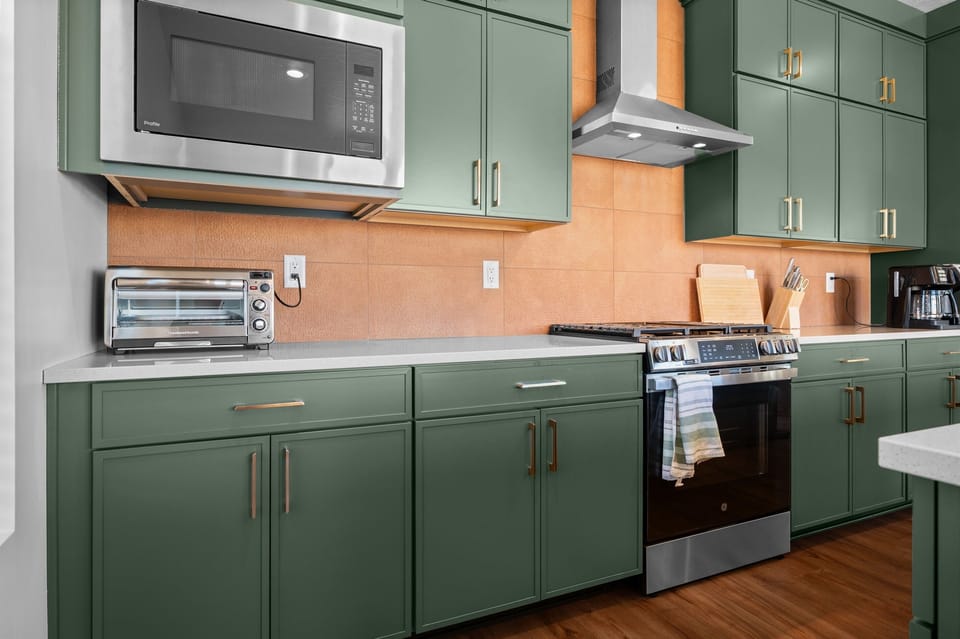 Sleek kitchen design featuring premium stainless-steel appliances and copper colored tile accents.