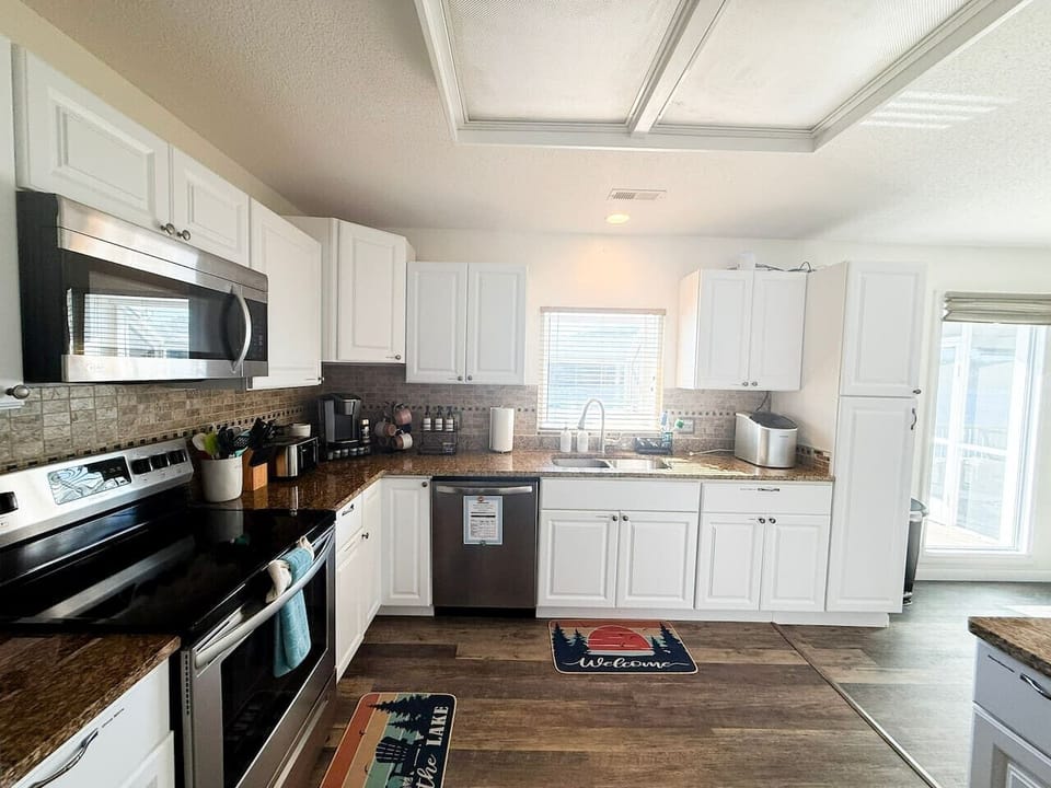 Fully equipped kitchen with stainless appliances, coffee station, and plenty of space to cook and gather.
