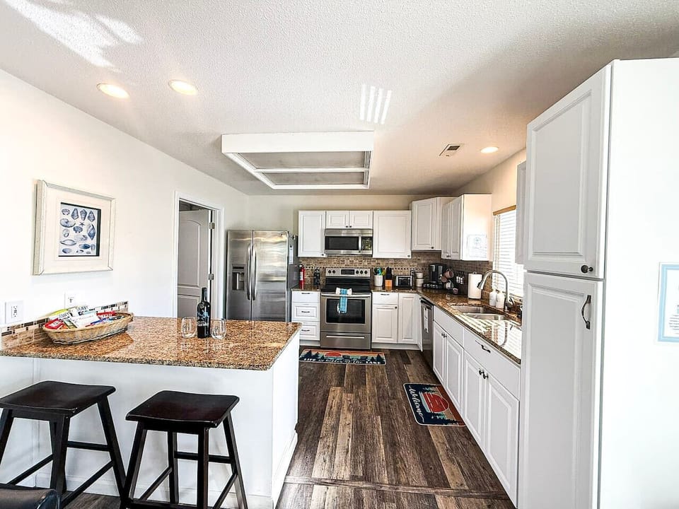 Fully equipped kitchen with stainless appliances and breakfast bar.