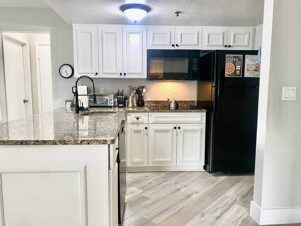 Fully equipped kitchen with electric cooktop,  full size fridge, microwave, toaster oven, dishwasher, waffle maker, coffee maker, all utensils - Sea World Orlando Apartments