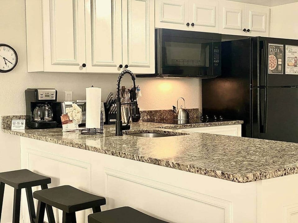 Fully equipped kitchen with electric cooktop,  full size fridge, microwave, toaster oven, dishwasher, waffle maker, coffee maker, all utensils- Sea World Orlando Apartments