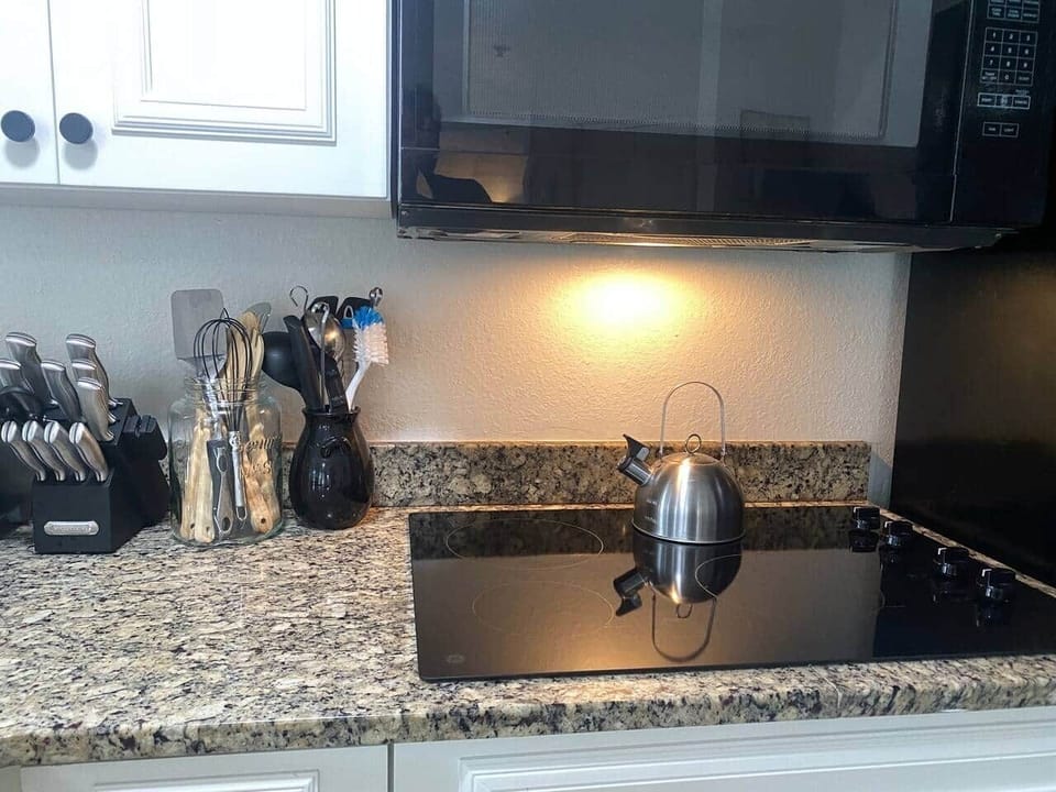Fully equipped kitchen with electric cooktop,  full size fridge, microwave, toaster oven, dishwasher, waffle maker, coffee maker, all utensils - Sea World Orlando Apartments