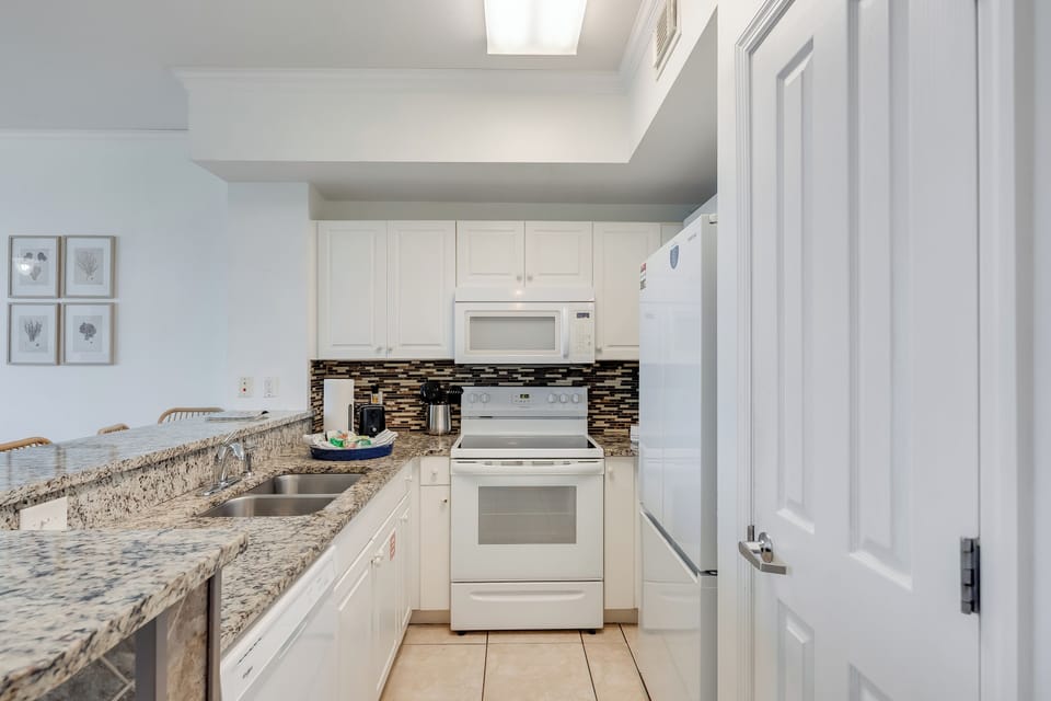 Fully equipped kitchen with granite counters—bright, modern, and ready to enjoy