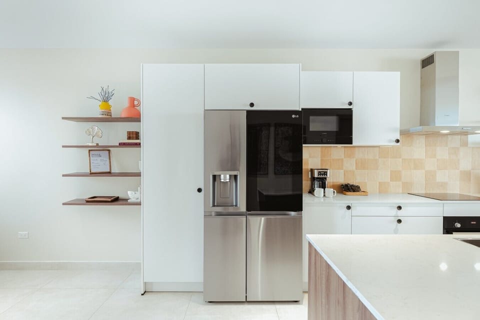 Fully equipped kitchen featuring modern appliances, cookware, essentials, and ample space for meal preparation.