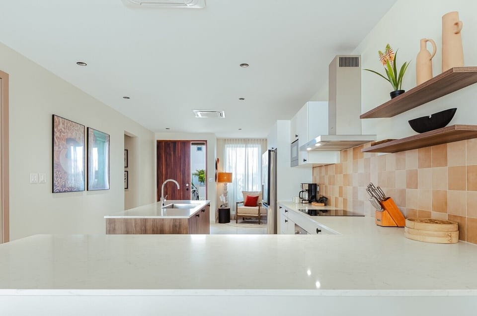 Fully equipped kitchen featuring modern appliances, cookware, essentials, and ample space for meal preparation.